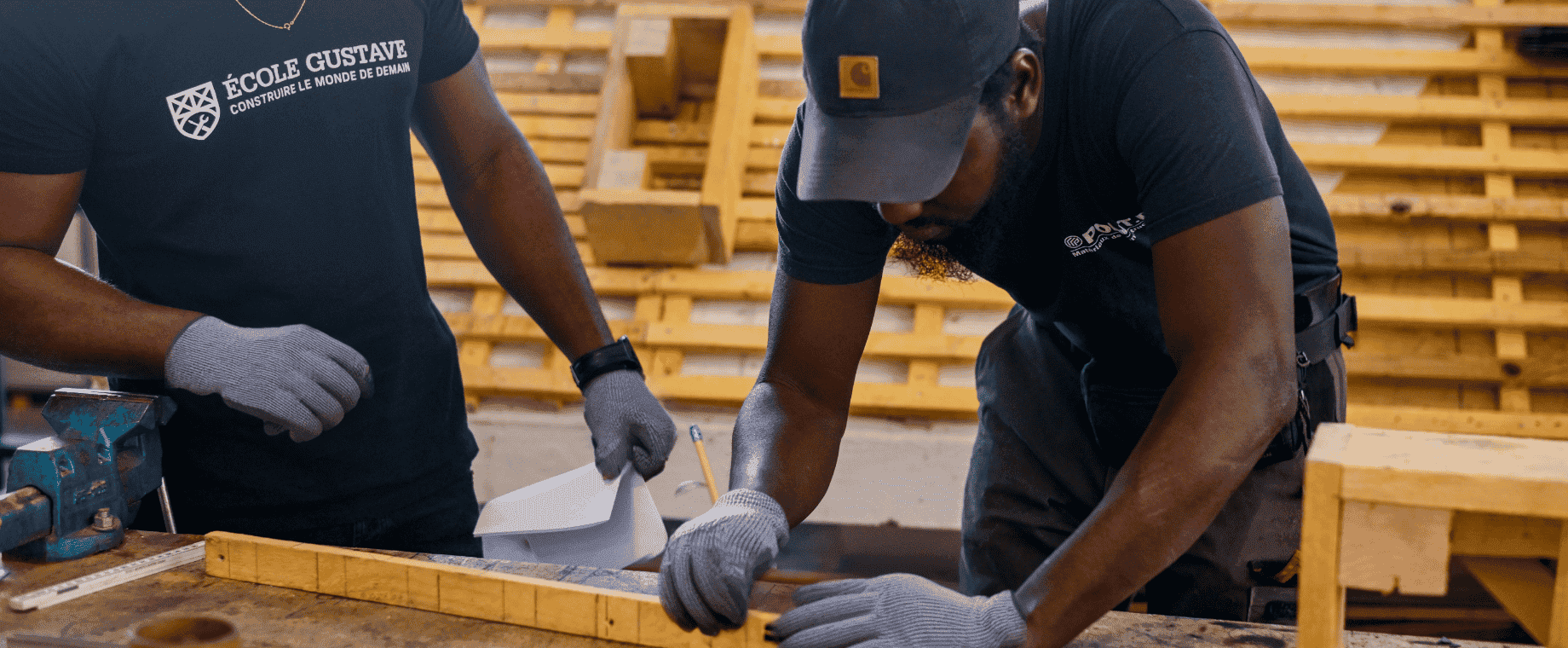 Un apprenant en formation de couvreur à l’École Gustave mesure des éléments en bois lors d’un atelier pratique.