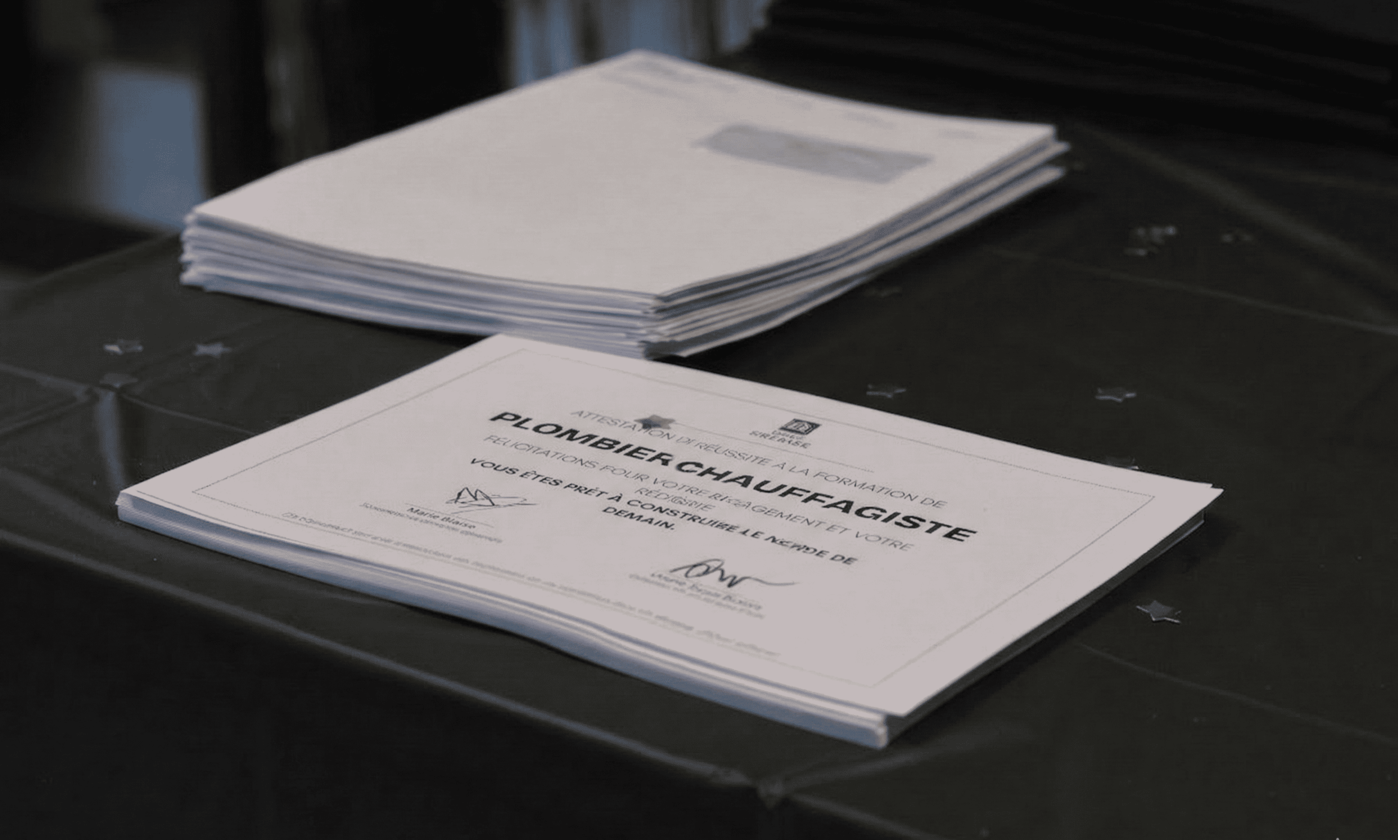 Certificat de fin de formation plombier chauffagiste posé sur une table lors d’une remise de diplômes à l’École Gustave.