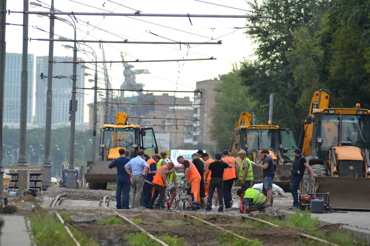 Équipe de maçons VRD sur un chantier de voirie avec engins de chantier et travaux de terrassement .