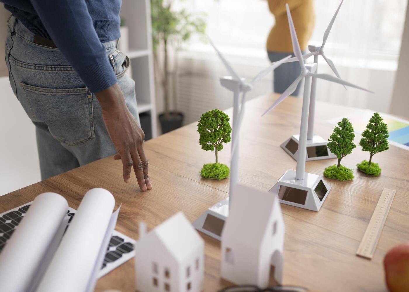 Maquettes de bâtiments xdurables avec éoliennes et panneaux solaires illustrant la RE2020