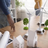 Maquettes de bâtiments xdurables avec éoliennes et panneaux solaires illustrant la RE2020