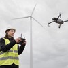 Femme ouvrière pilotant un drone sur un chantier connecté