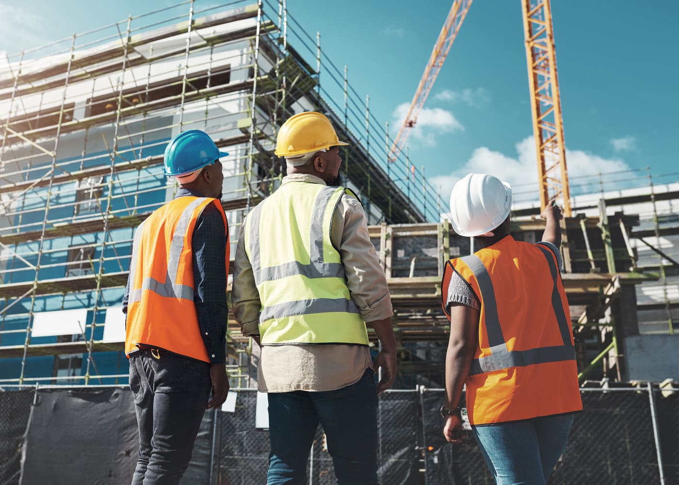 évolution carrière BTP : ouvriers en tenue de sécurité observant un chantier