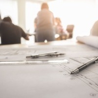 Plans techniques, outils et casque de chantier dans un bureau de formation BTP