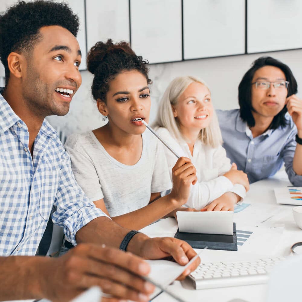 Adultes en formation travaillant en groupe dans un espace moderne