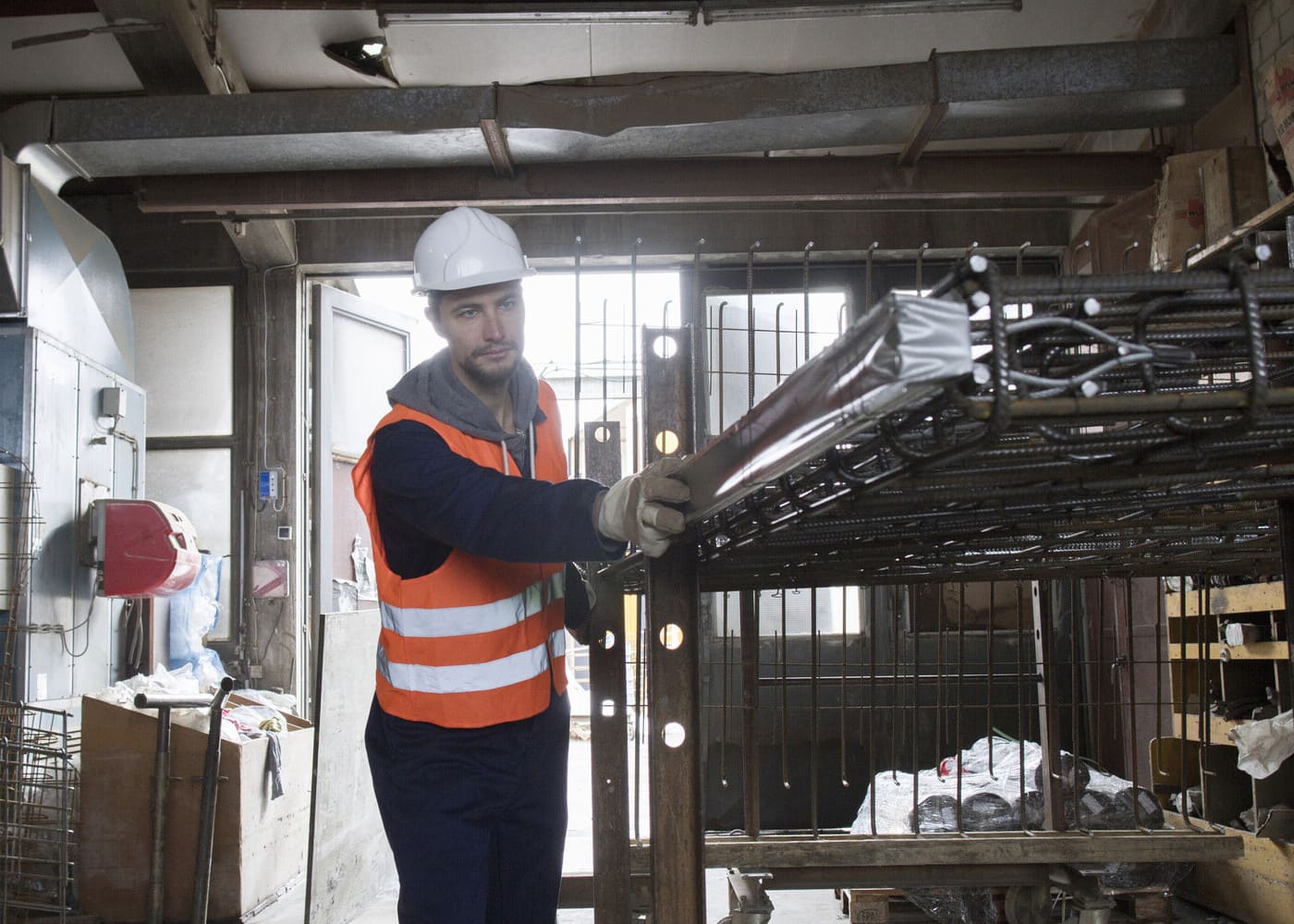 Artisan BTP au travail sur un ferraillage dans un atelier